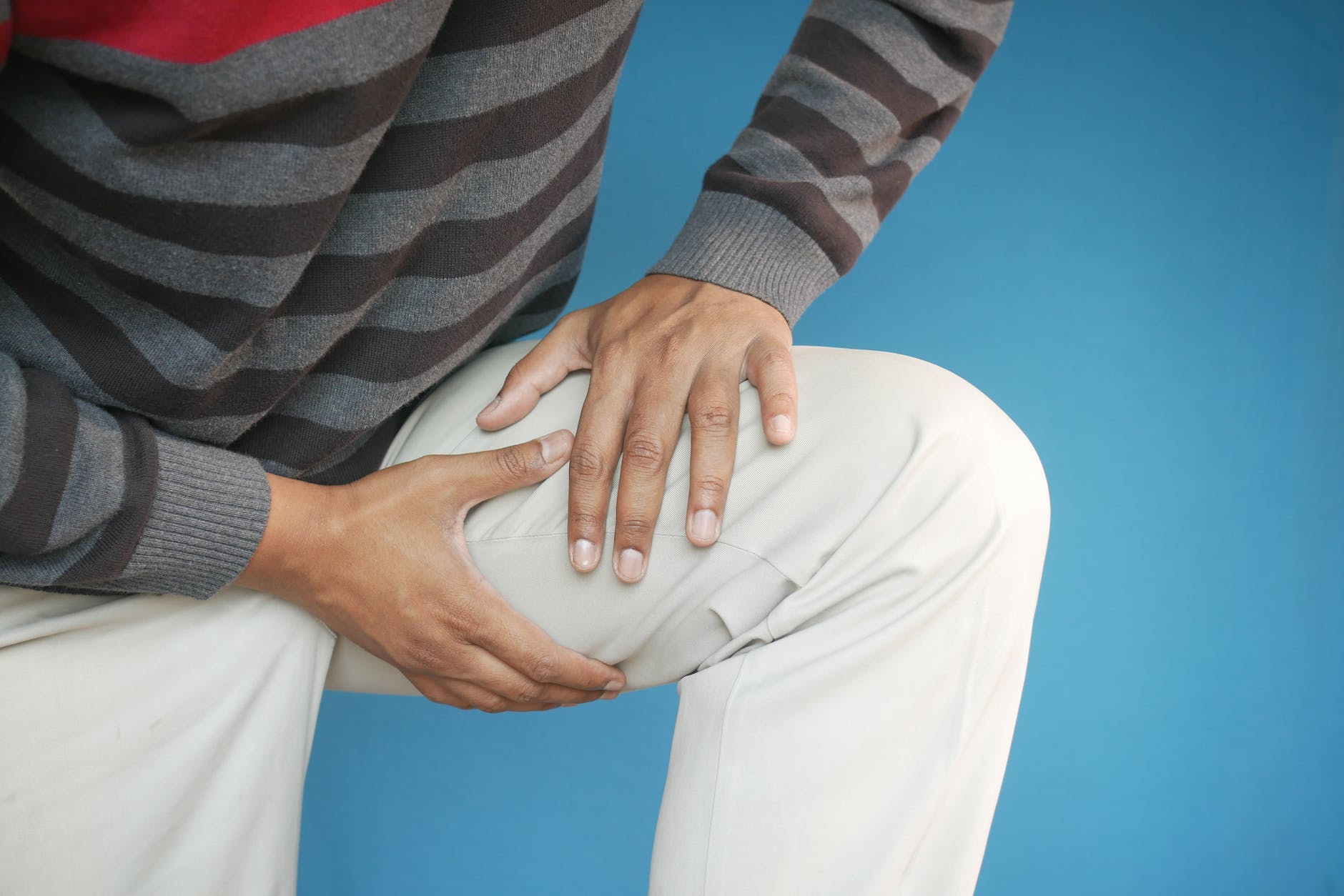 man in pain holding his thigh