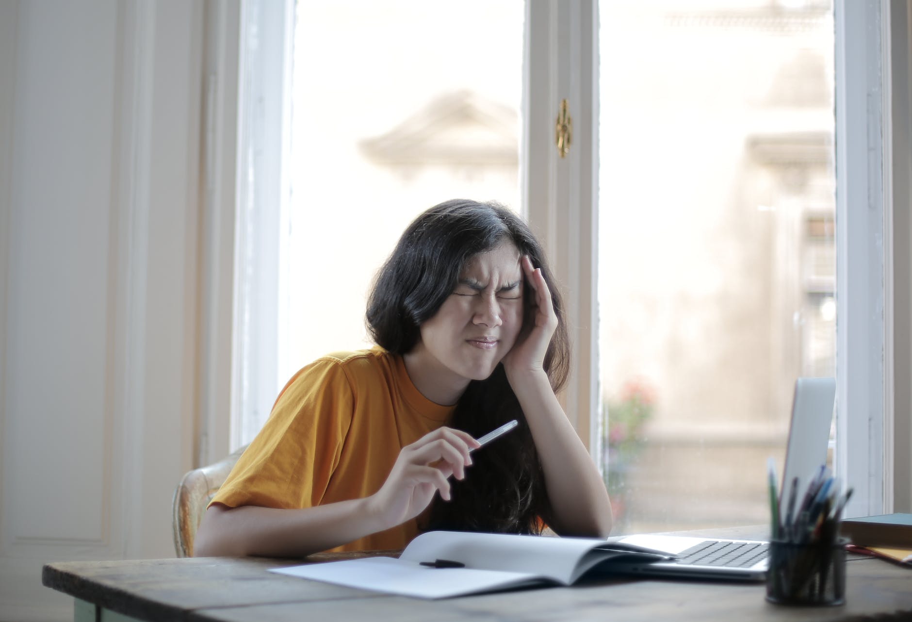 female student suffering from headache at home