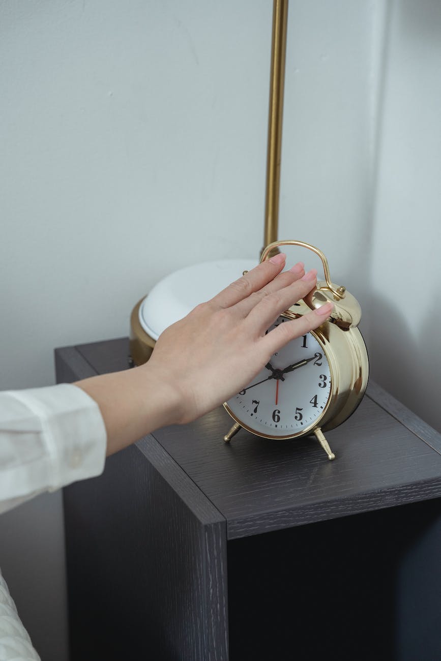 close up of hand turning off classic clock
